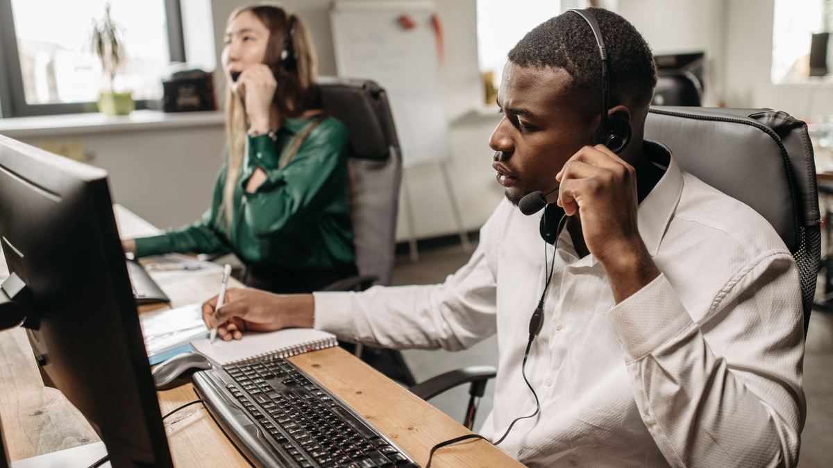 IT support specialist with a headset working at a computer